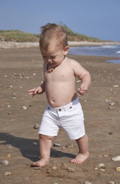 İtalya, Sicilya, Akdeniz; Kumsalda oynarken bir yıl yaşlı erkek çocuk 