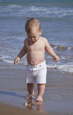 İtalya, Sicilya, Akdeniz; Kumsalda oynarken bir yıl yaşlı erkek çocuk 