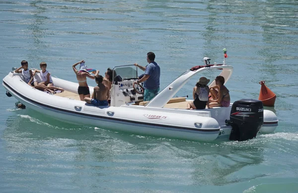 Italia, Sicilia, Mar Mediterráneo, Marina di Ragusa; 30 Julio 2017, personas en un gran barco de goma en el puerto - EDITORIAL — Foto de Stock