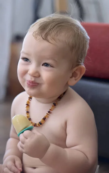 Portrait of a one year old male child licking an ice cream indoors — Stock Photo, Image