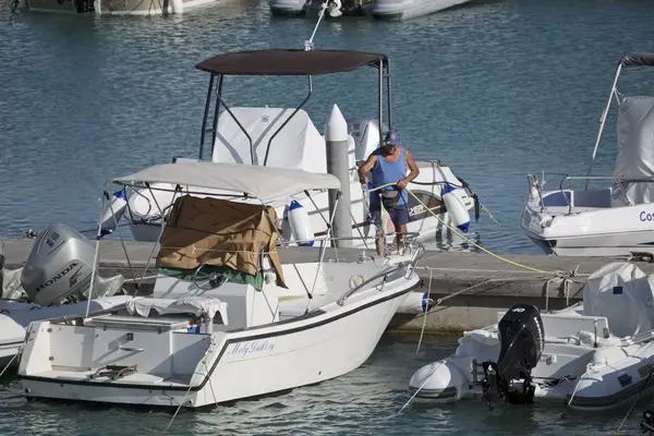 Italien, Sizilien, Mittelmeer, Marina di ragusa; 5. September 2017, Fischer wäscht sein Motorboot im Hafen - Leitartikel — Stockfoto