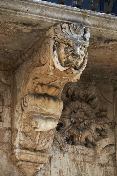 Italie, Sicile, Scicli (province de Raguse), façade du palais baroque Fava de l'Unesco (XVIIIe siècle apr. J.-C.), statue sous un balcon — Photo