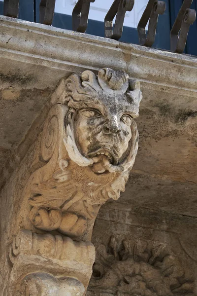 Italie, Sicile, Scicli (province de Raguse), façade du palais baroque Fava de l'Unesco (XVIIIe siècle apr. J.-C.), statue sous un balcon — Photo