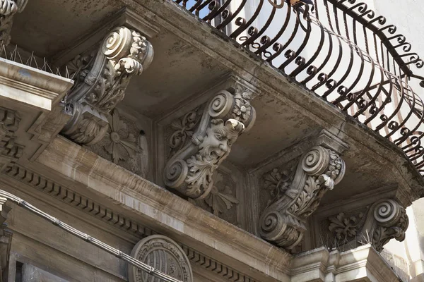 İtalya, Sicilya, Scicli (Ragusa eyaletinde), Unesco Barok Spadaro Palace cephe (18. yüzyıl a.C.), balkon altında süs heykeller  