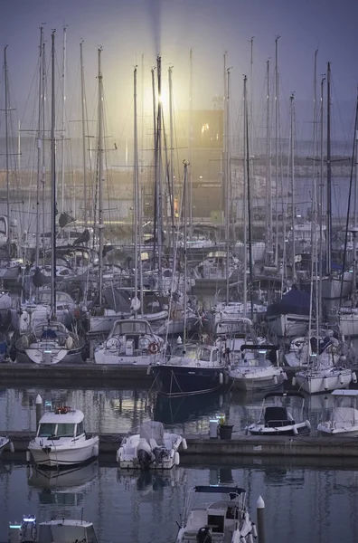 Włochy, Sycylia, Morze Śródziemne, Marina di Ragusa; 12 listopada 2017, łodzie i luksusowe jachty w porcie w mglisty zachód słońca - Redakcja — Zdjęcie stockowe