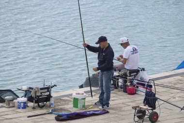 İtalya, Sicilya, Marina di Ragusa (Ragusa Eyaleti); 3 Kasım 2019, balıkçılar limanda balık avlıyor - Editörlük