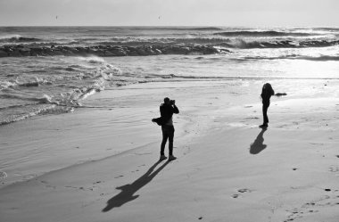İtalya, Sicilya, Akdeniz, Marina di Ragusa (Ragusa Eyaleti), sahilde bir kadının fotoğraflarını çeken fotoğrafçı.