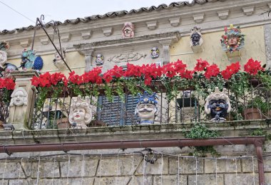 İtalya, Sicilya, Palazzolo Acreide (Syracuse Eyaleti); kasabanın merkez caddesindeki bir Özgürlük Sarayı 'nın balkonunda seramik heykeller ve bitkiler 