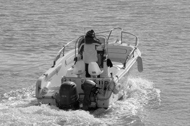 İtalya, Sicilya, Akdeniz, Marina di Ragusa (Ragusa Eyaleti); 11 Ocak 2020, limandaki bir motorlu teknede adam - Editör