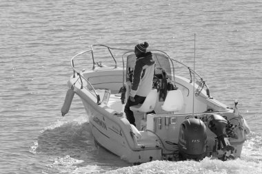 İtalya, Sicilya, Akdeniz, Marina di Ragusa (Ragusa Eyaleti); 11 Ocak 2020, limandaki bir motorlu teknede adam - Editör