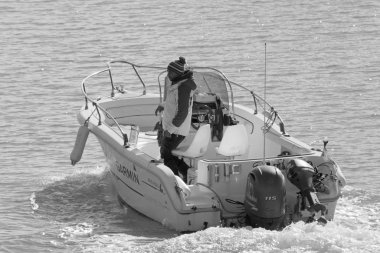 İtalya, Sicilya, Akdeniz, Marina di Ragusa (Ragusa Eyaleti); 11 Ocak 2020, limandaki bir motorlu teknede adam - Editör