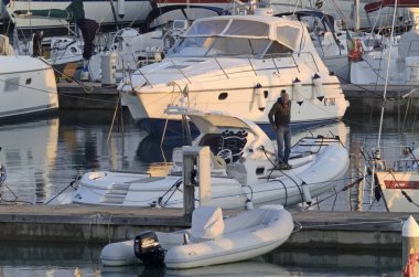 İtalya, Sicilya, Akdeniz, Marina di Ragusa (Ragusa Eyaleti); 15 Ocak 2020, gün batımında limanda bir kauçuk teknede adam - Editör