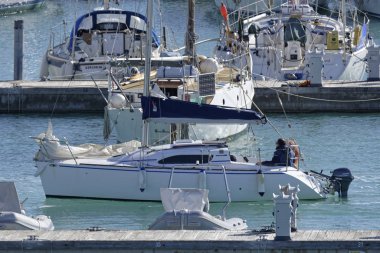 İtalya, Sicilya, Akdeniz, Marina di Ragusa (Ragusa Eyaleti); 18 Ocak 2020, limandaki bir yelkenli teknesinde adam