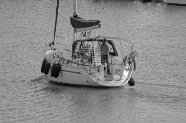 İtalya, Sicilya, Akdeniz, Marina di Ragusa (Ragusa Eyaleti); 1 Şubat 2020, limandaki bir yelkenli teknesinde adam