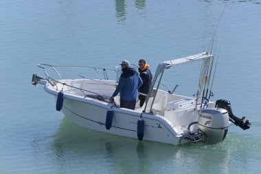 İtalya, Sicilya, Akdeniz, Marina di Ragusa (Ragusa Eyaleti); 9 Şubat 2020, limandaki bir motorlu teknede balıkçılar