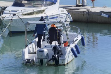 İtalya, Sicilya, Akdeniz, Marina di Ragusa (Ragusa Eyaleti); 9 Şubat 2020, limandaki bir motorlu teknede balıkçılar