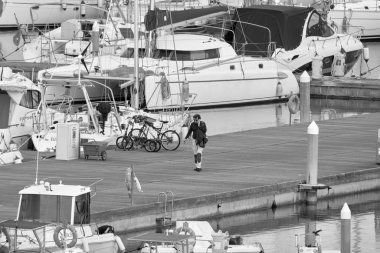 Italy, Sicily, Mediterranean Sea, Marina di Ragusa (Ragusa Province); 16 February 2020, man on the phone and luxury yachts in the port - EDITORIAL