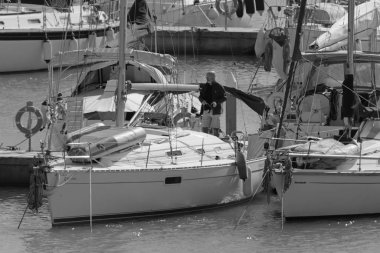 İtalya, Sicilya, Akdeniz, Marina di Ragusa (Ragusa Eyaleti); 25 Şubat 2020, limandaki bir yelkenli teknesinde adam