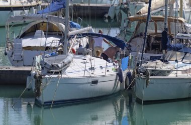 İtalya, Sicilya, Akdeniz, Marina di Ragusa (Ragusa Eyaleti); 1 Mart 2020, limandaki bir yelkenli teknesindeki insanlar