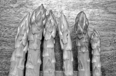 Yiyecek; ahşap bir masada taze kuşkonmaz.