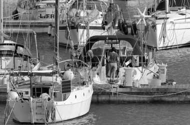 İtalya, Sicilya, Akdeniz, Marina di Ragusa (Ragusa Eyaleti); 4 Nisan 2020, limandaki insanlar ve yelkenliler - EDITORIAL