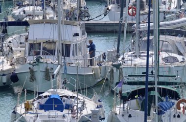 İtalya, Sicilya, Akdeniz, Marina di Ragusa (Ragusa Eyaleti); 11 Nisan 2020, limandaki insanlar ve lüks yatlar - EDITORIAL