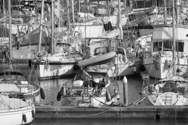 İtalya, Sicilya, Akdeniz, Marina di Ragusa (Ragusa Eyaleti); 12 Nisan 2020, limandaki bir yelkenli teknesinde adam - EDITORIAL