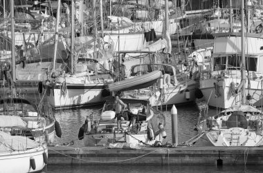İtalya, Sicilya, Akdeniz, Marina di Ragusa (Ragusa Eyaleti); 12 Nisan 2020, limandaki bir yelkenli teknesinde adam - EDITORIAL