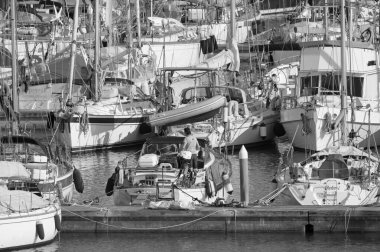 İtalya, Sicilya, Akdeniz, Marina di Ragusa (Ragusa Eyaleti); 12 Nisan 2020, limandaki bir yelkenli teknesinde adam - EDITORIAL