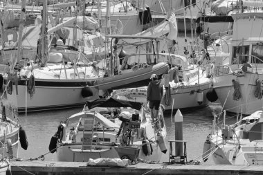 İtalya, Sicilya, Akdeniz, Marina di Ragusa (Ragusa Eyaleti); 15 Nisan 2020, limandaki bir yelkenli teknesinde adam - EDITORIAL