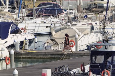 İtalya, Sicilya, Akdeniz, Marina di Ragusa (Ragusa Eyaleti); 19 Nisan 2020, limandaki insanlar ve lüks yatlar - EDITORIAL