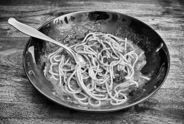 夕食後 木製のテーブルの上に皿の中に残されたトマトソースイタリアのパスタ — ストック写真