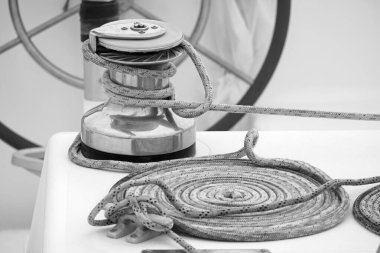Italy, Sicily, Mediterranean Sea, Marina di Ragusa (Ragusa Province); the boat's wheel, a winch and nautical ropes on a sailing boat in the port 