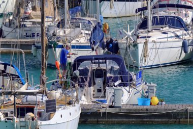 İtalya, Sicilya, Akdeniz, Marina di Ragusa (Ragusa Eyaleti); 1 Mayıs 2020, limandaki bir yelkenli teknesinde adam - EDITORIAL