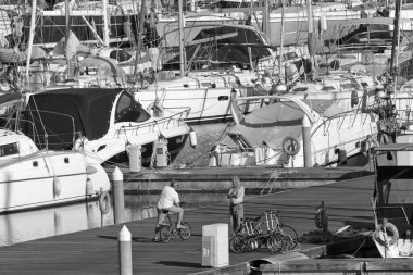 İtalya, Sicilya, Akdeniz, Marina di Ragusa (Ragusa Eyaleti); 4 Mayıs 2020, limandaki insanlar ve lüks yatlar - EDITORIAL