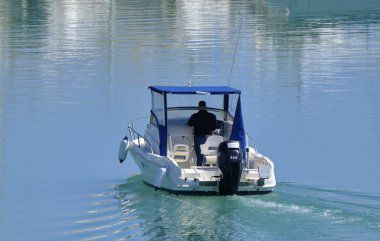 İtalya, Sicilya, Akdeniz, Marina di Ragusa (Ragusa Eyaleti); 5 Mayıs 2020, limandaki bir motorlu teknede adam - EDITORIAL