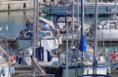 İtalya, Sicilya, Akdeniz, Marina di Ragusa (Ragusa Eyaleti); 6 Mayıs 2020, limandaki bir yelkenli teknesinde adam - EDITORIAL