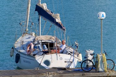 İtalya, Sicilya, Akdeniz, Marina di Ragusa (Ragusa ili); 8 Mayıs 2020, limandaki bir yelkenli teknesinde insanlar - EDITORIAL