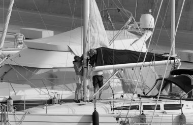 İtalya, Sicilya, Akdeniz, Marina di Ragusa (Ragusa ili); 8 Mayıs 2020, limandaki bir yelkenli teknesinde insanlar - EDITORIAL