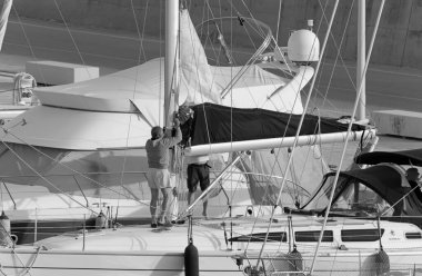 İtalya, Sicilya, Akdeniz, Marina di Ragusa (Ragusa ili); 8 Mayıs 2020, limandaki bir yelkenli teknesinde insanlar - EDITORIAL