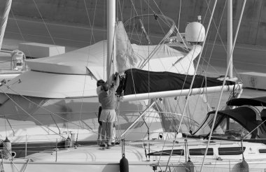 İtalya, Sicilya, Akdeniz, Marina di Ragusa (Ragusa ili); 8 Mayıs 2020, limandaki bir yelkenli teknesinde insanlar - EDITORIAL