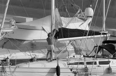 İtalya, Sicilya, Akdeniz, Marina di Ragusa (Ragusa ili); 8 Mayıs 2020, limandaki bir yelkenli teknesinde insanlar - EDITORIAL