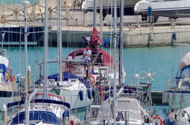 İtalya, Sicilya, Akdeniz, Marina di Ragusa (Ragusa Eyaleti); 9 Mayıs 2020, limandaki bir yelkenli teknesinde adam - EDITORIAL