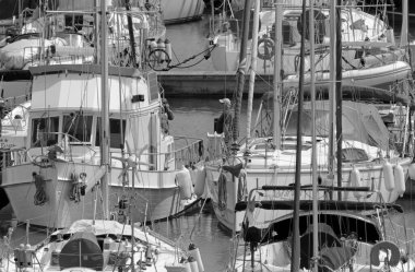 İtalya, Sicilya, Akdeniz, Marina di Ragusa (Ragusa Eyaleti); 9 Mayıs 2020, limandaki insanlar ve lüks yatlar - EDITORIAL