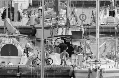 İtalya, Sicilya, Akdeniz, Marina di Ragusa (Ragusa Eyaleti); 9 Mayıs 2020, limandaki insanlar ve yelkenliler - EDITORIAL