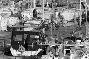 İtalya, Sicilya, Akdeniz, Marina di Ragusa (Ragusa Eyaleti); 12 Mayıs 2020, limandaki insanlar ve lüks yatlar - EDITORIAL