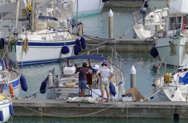 İtalya, Sicilya, Akdeniz, Marina di Ragusa (Ragusa Eyaleti); 15 Mayıs 2020, limandaki insanlar ve lüks yatlar - EDITORIAL