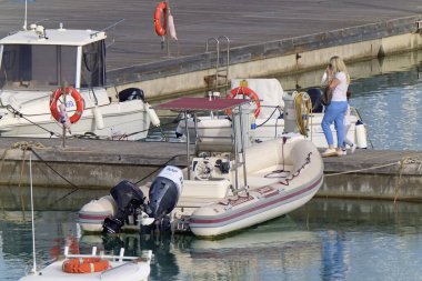 İtalya, Sicilya, Akdeniz, Marina di Ragusa; 15 Mayıs 2020, limanda motorlu tekneleri olan insanlar - EDITORIAL