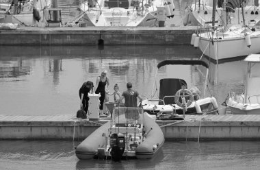 İtalya, Sicilya, Akdeniz, Marina di Ragusa (Ragusa Eyaleti); 17 Mayıs 2020, limandaki insanlar, motorlu tekneler ve lüks yatlar - EDITORIAL