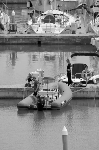 İtalya, Sicilya, Akdeniz, Marina di Ragusa (Ragusa Eyaleti); 17 Mayıs 2020, limandaki insanlar, motorlu tekneler ve lüks yatlar - EDITORIAL